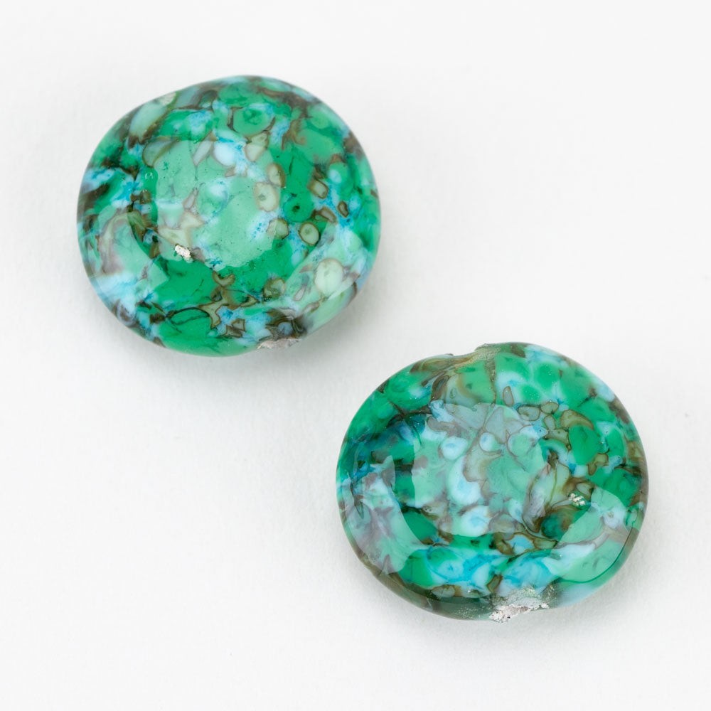 Two premium glass beads from Unicorne Beads. Each Bead has a blue, green, brown color pattern and feature a hollow center to be used for jewelry making.