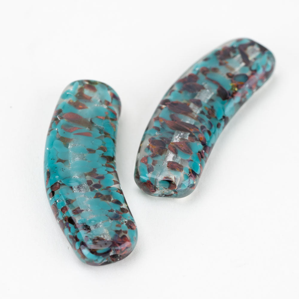 A set of two banana shaped, colored with turquoise and copper in a random pattern. Each bead features a hollow hole lengthwise used in the process of jewelry making.