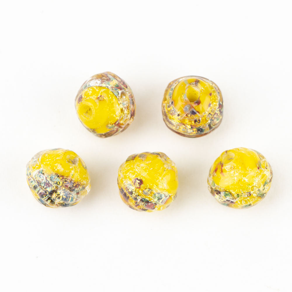 Five yellow glass beads with colorful dichroic coloring embedded made by Unicorne Beads. Each bead is shaped like a coconut and has a hollow hole to be used for making bracelets and other jewelry projects.