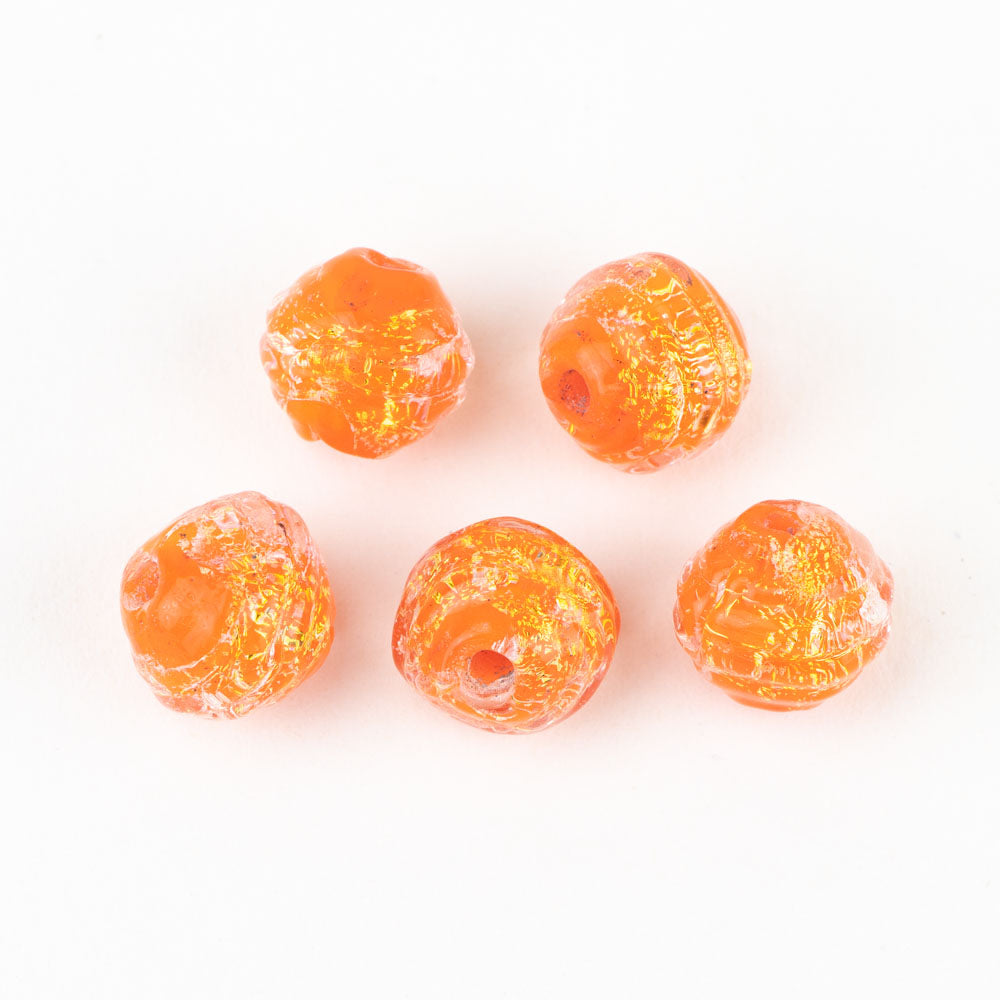 Five individual glass beads with orange and yellow coloring. Each bead has a hollow center to be used for jewelry making. 