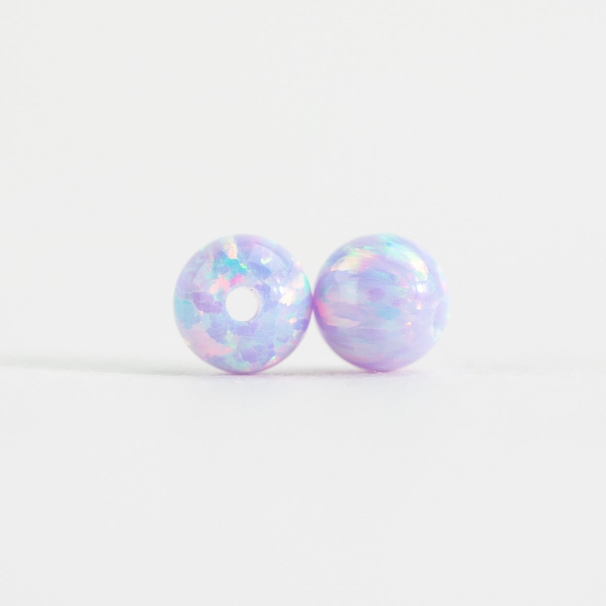 Pair of iridescent donut-shaped earrings on a white background