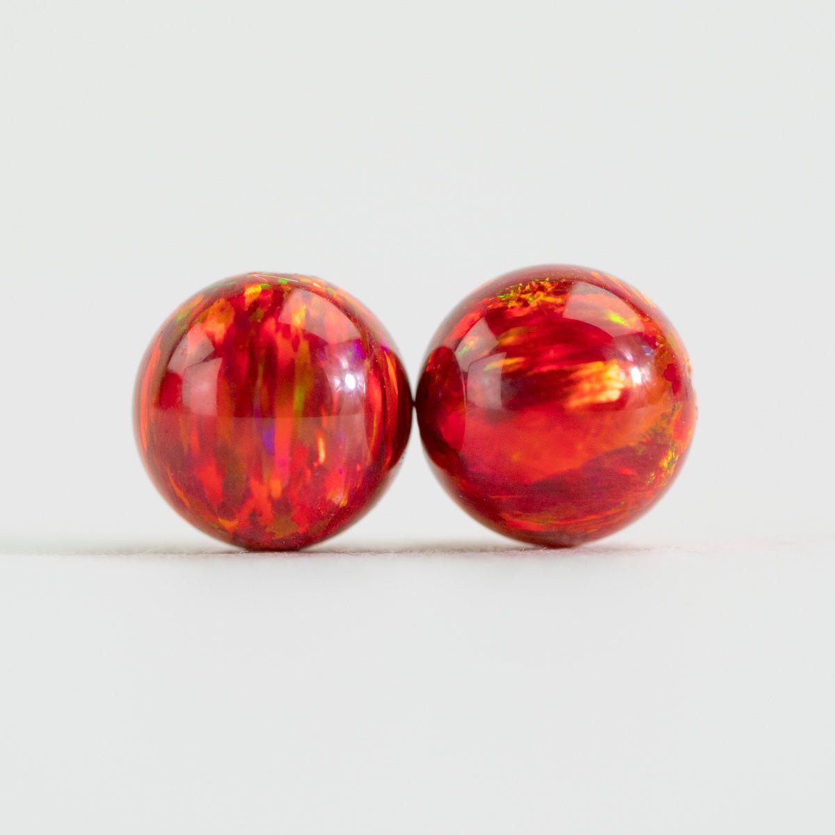 Two small red cherry beads on white background
