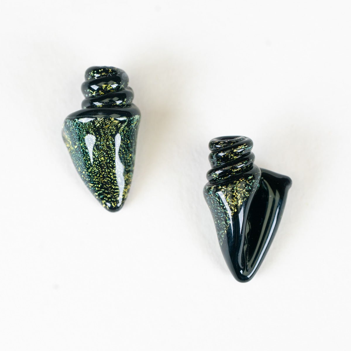 Two black and gold decorative beads on a white background