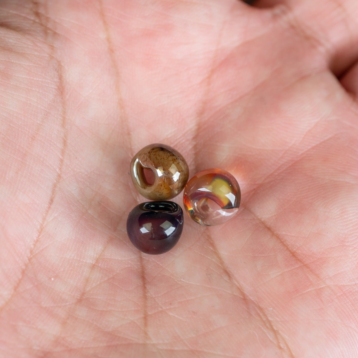Three glass teardrop beads on hand