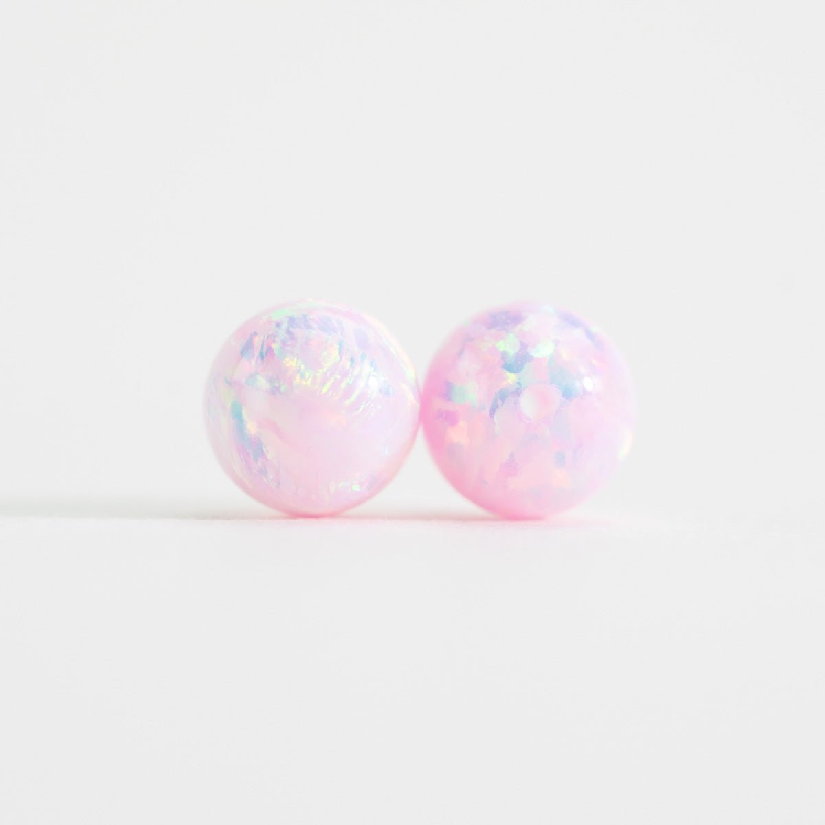 Pair of pink and white opal beads on a white background