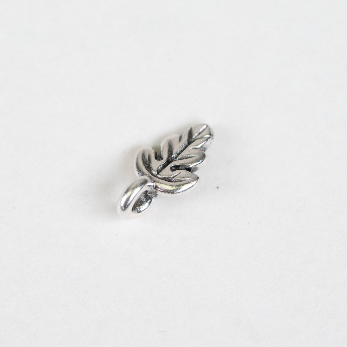 Oak leaf shaped charm bead on a white background