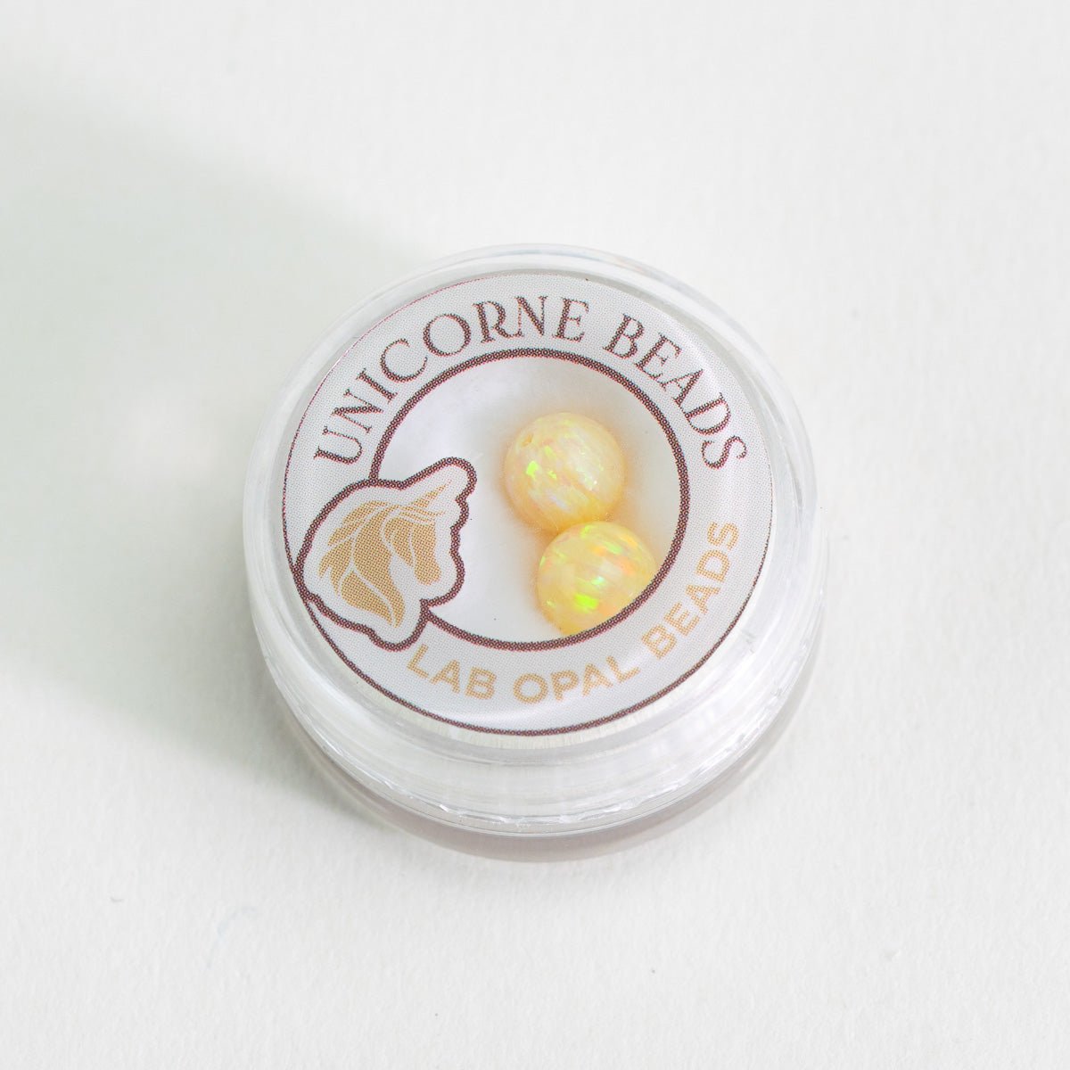 Container of Unicorne Beads Lab Opal Beads on a white background