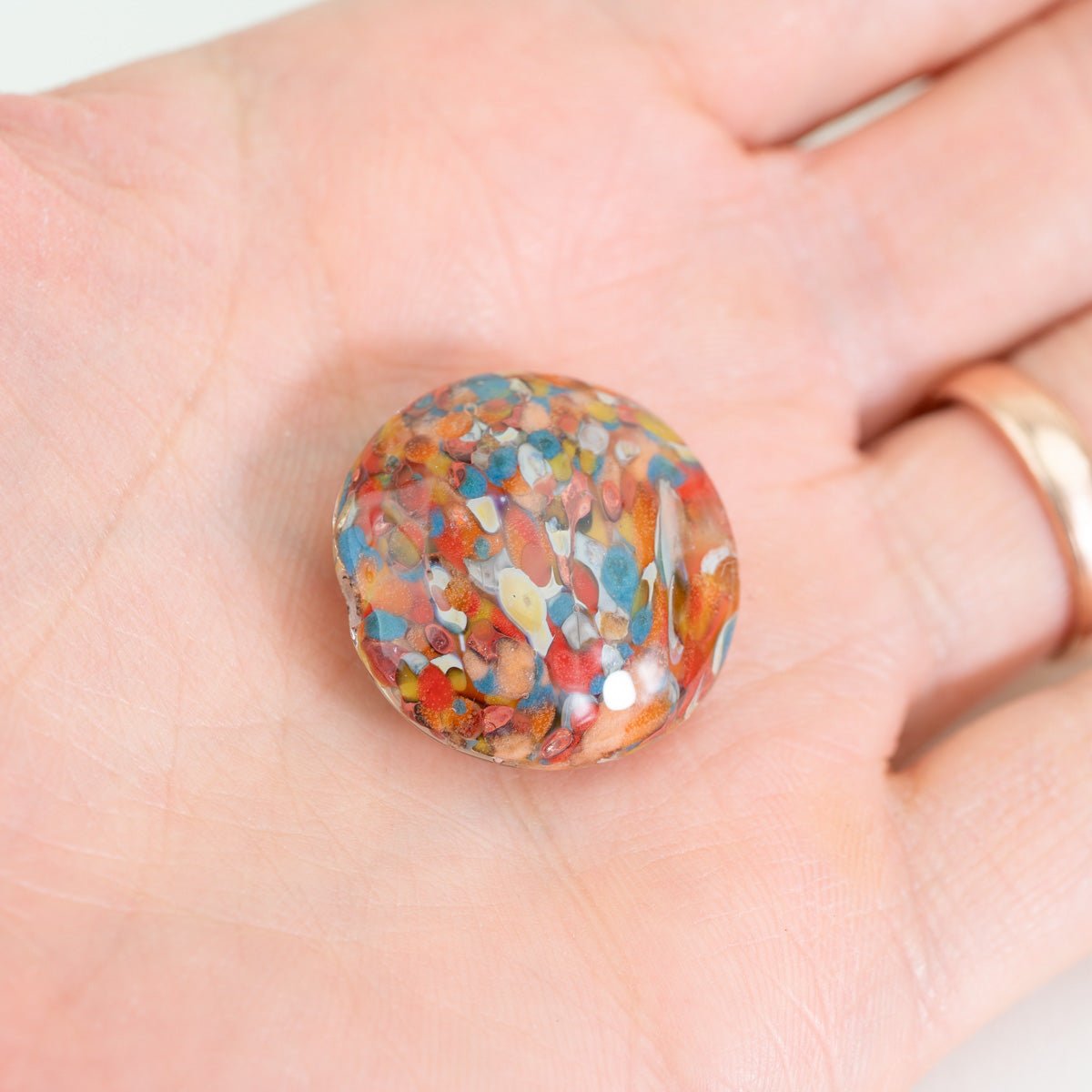 Multicolor Bird of Paradise coin glass bead featuring layered organic color fragments
