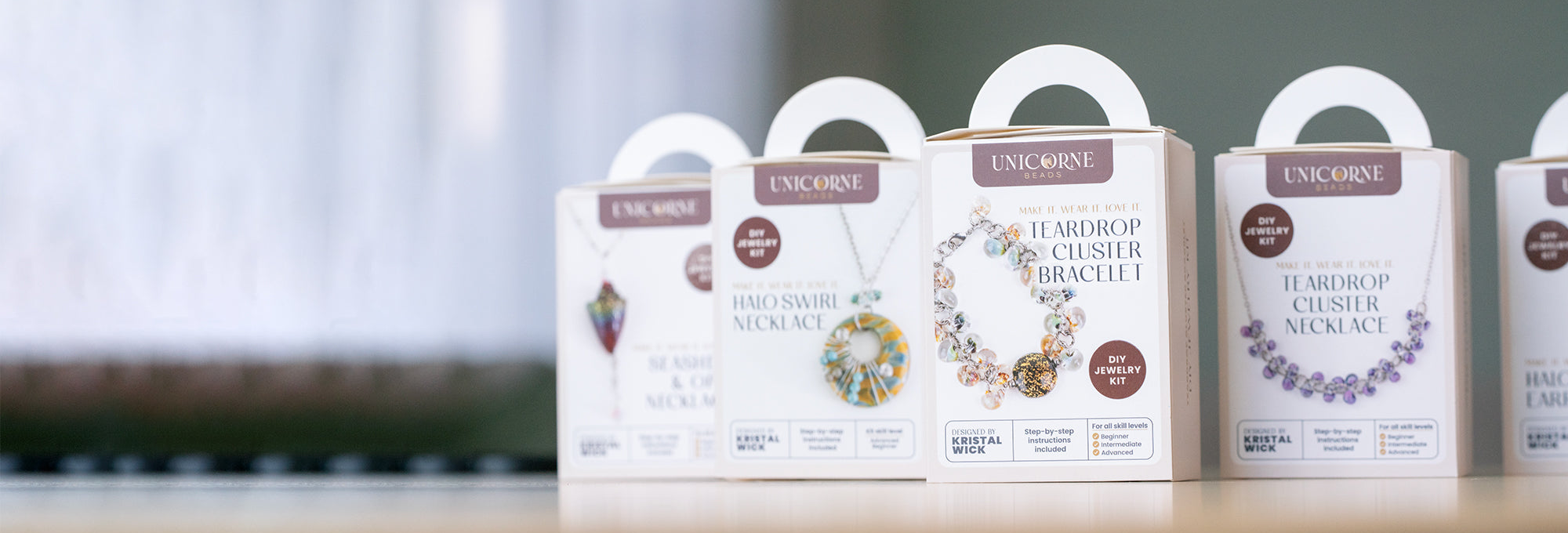 A collection of DIY glass bead jewelry kits together on a table