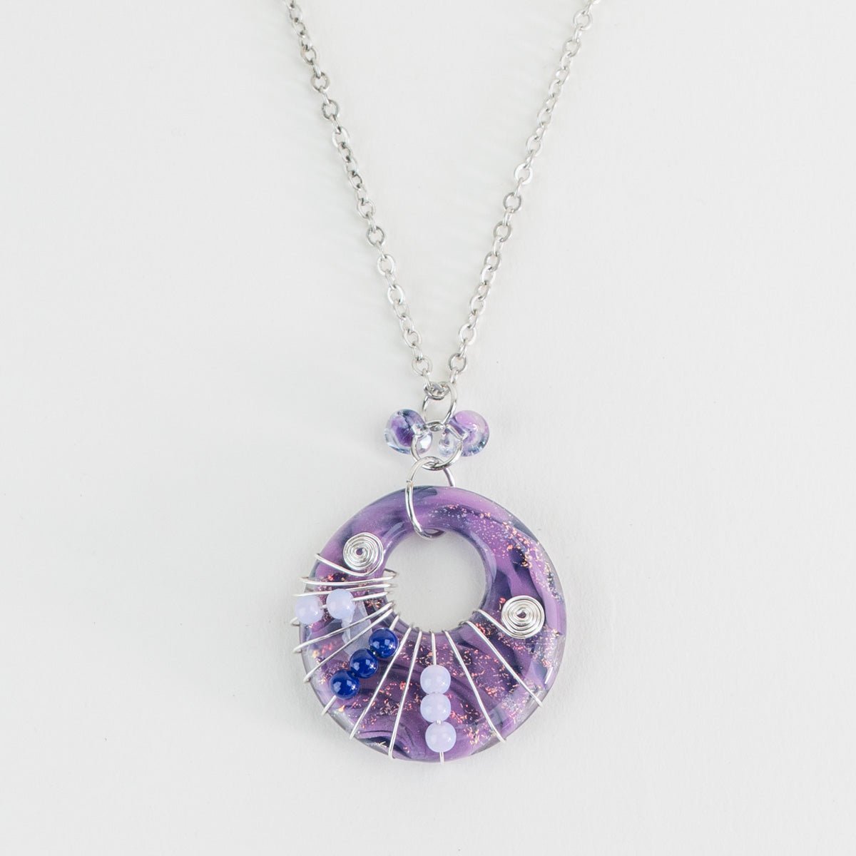 Close up of purple halo swirl glass pendant with wire wrap accents
