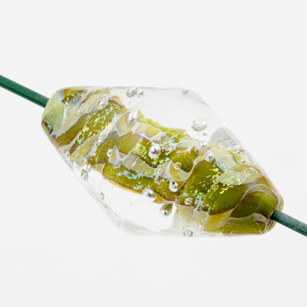 Bicone shaped glass bead with a clear outer shell and greenish-yellow bore. Silver beads embedded in the clear shell. Bead has two holes on each side allowing for string to be placed through the core for use in jewelry making. 