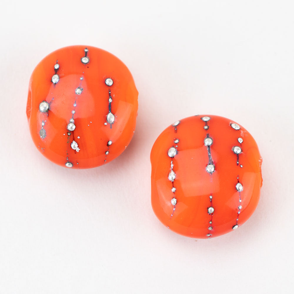 Two orange glass beads resembling a pumpkin. These beads are crafted by Unicorne Beads and feature a hollow center to be used for jewelry pieces.