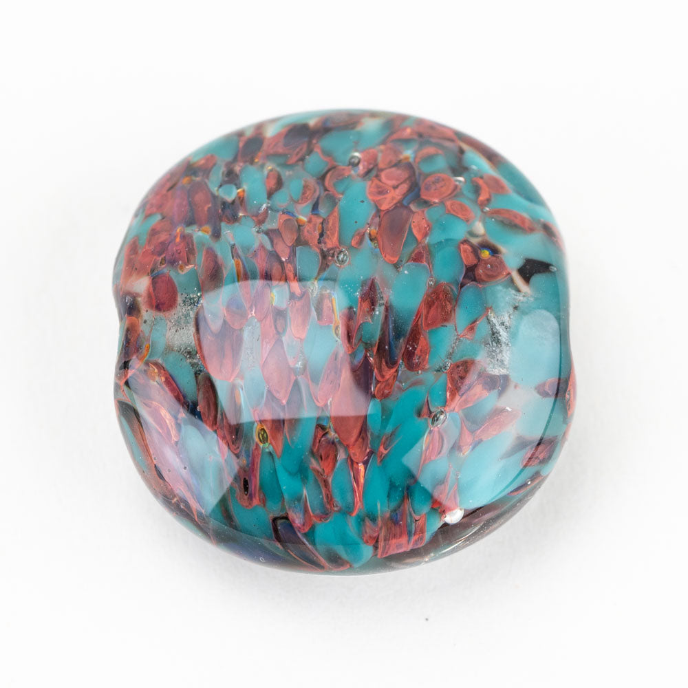 One large glass bead with copper and teal coloring mixed throughout with a uniformed pattern. The bead has a hollow center to be used for jewelry projects such as necklace design. 