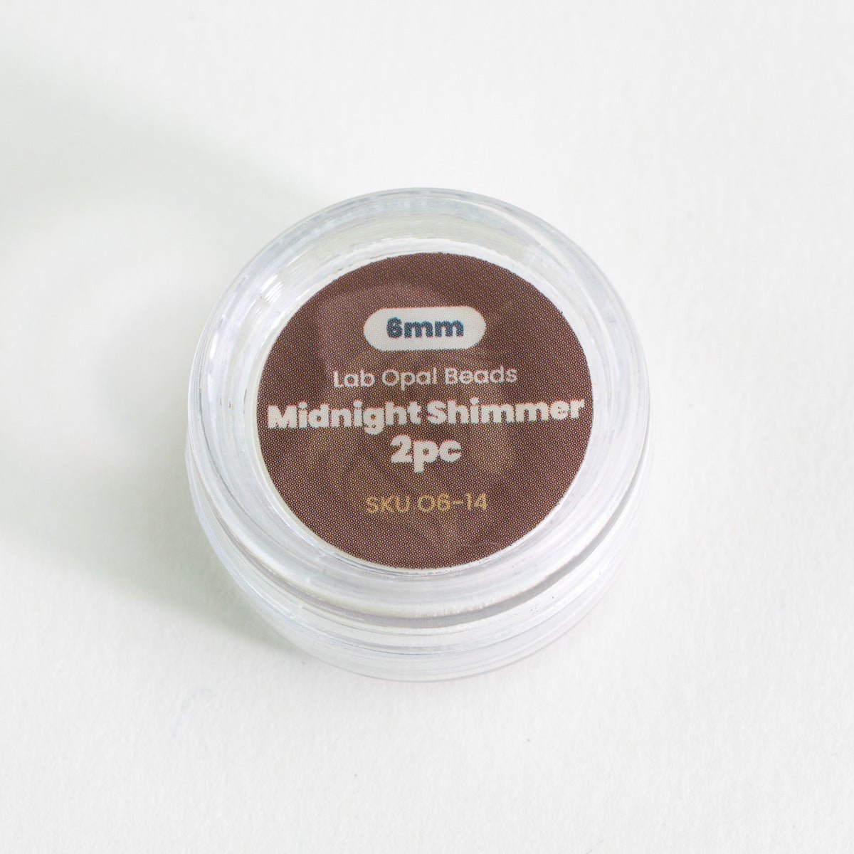 Container of lab opal beads labeled 'Midnight Shimmer 2pc' on a white background