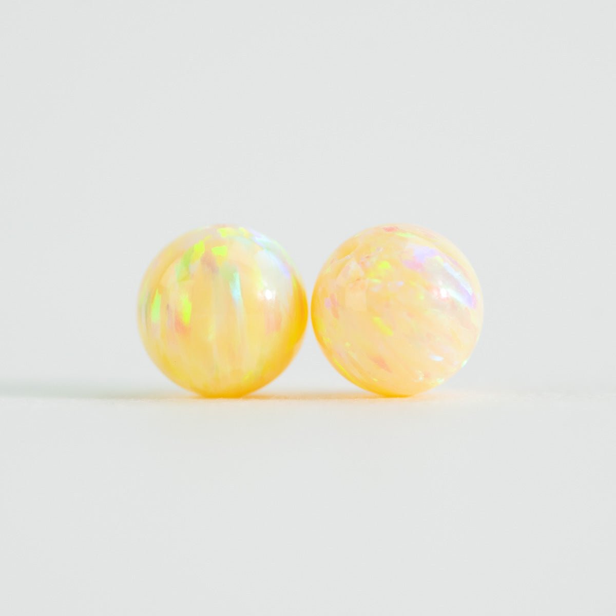 Pair of opal lab beads yellow on white background