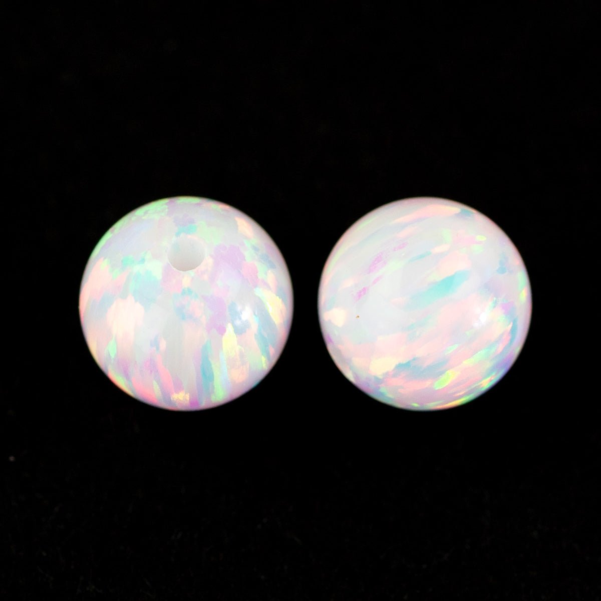Two round white snow beads on black background