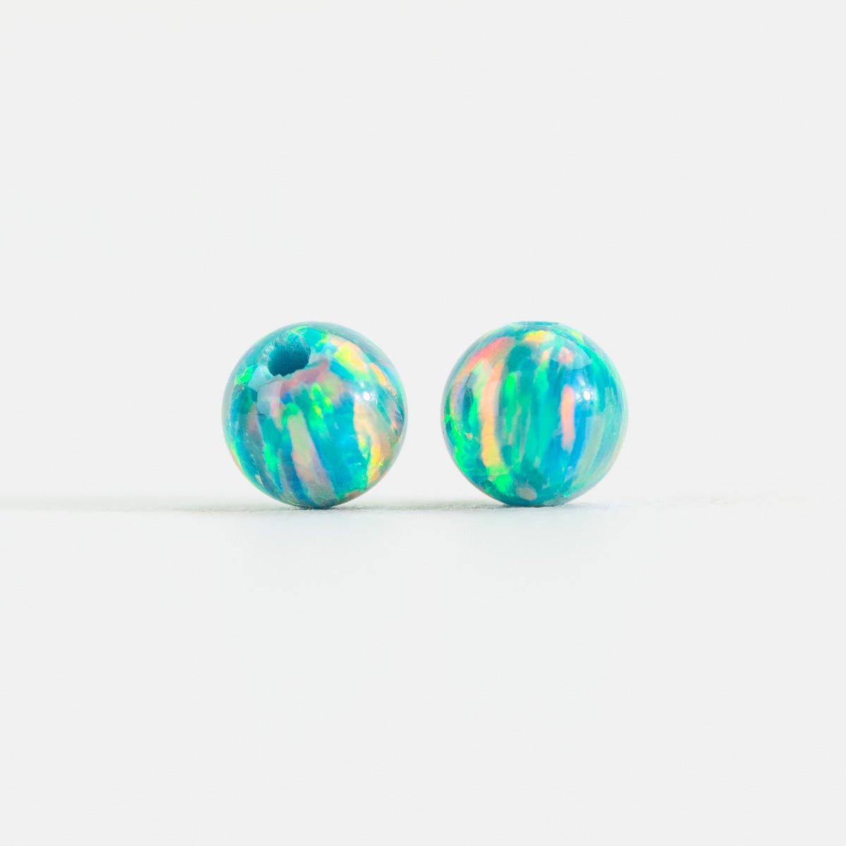 Two colorful marbled beads on a white background