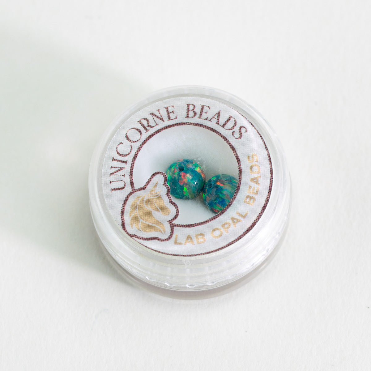 Unicorne Beads container with colorful beads on a white background