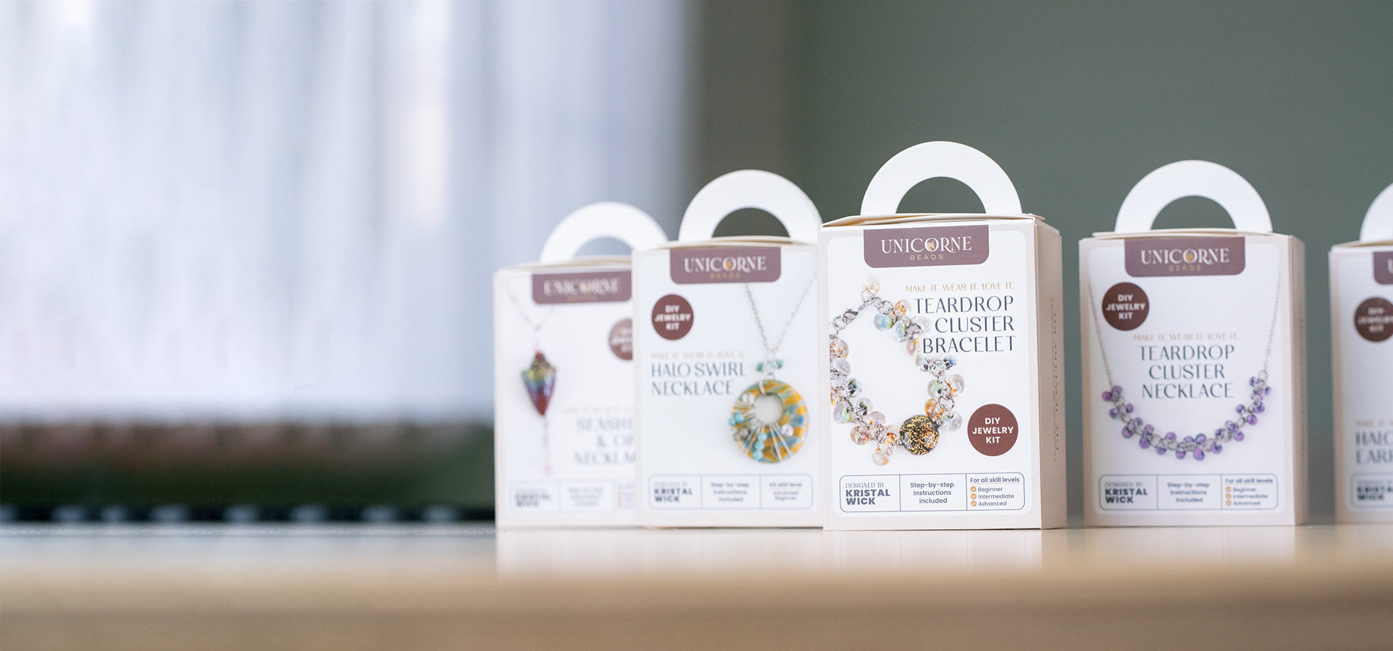 A group of DIY Jewelry Kits by Unicorne Beads showcasing packaging and glass bead pieces.
