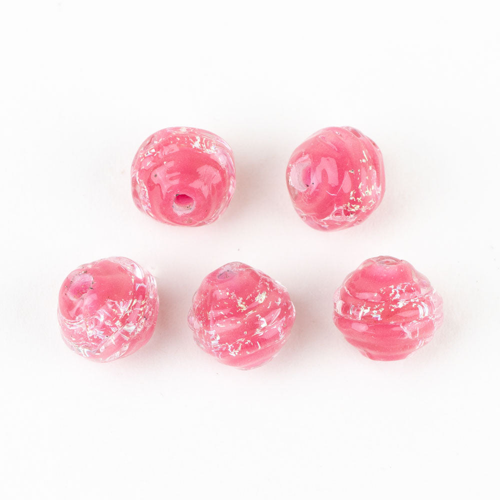 Five pink coconut shaped beads from Unicorne Beads. Dichroic coloring is seen embedded in each bead. Two holes are in each bead to allow for string to be threaded through for use in jewelry projects.