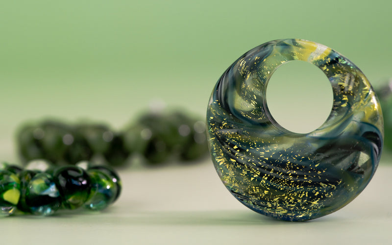 Closeup of green glass bead on green background