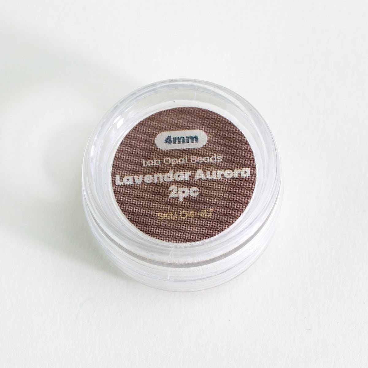 Container of lab opal beads labeled 'Lavendar Aurora 2pc' on a white background