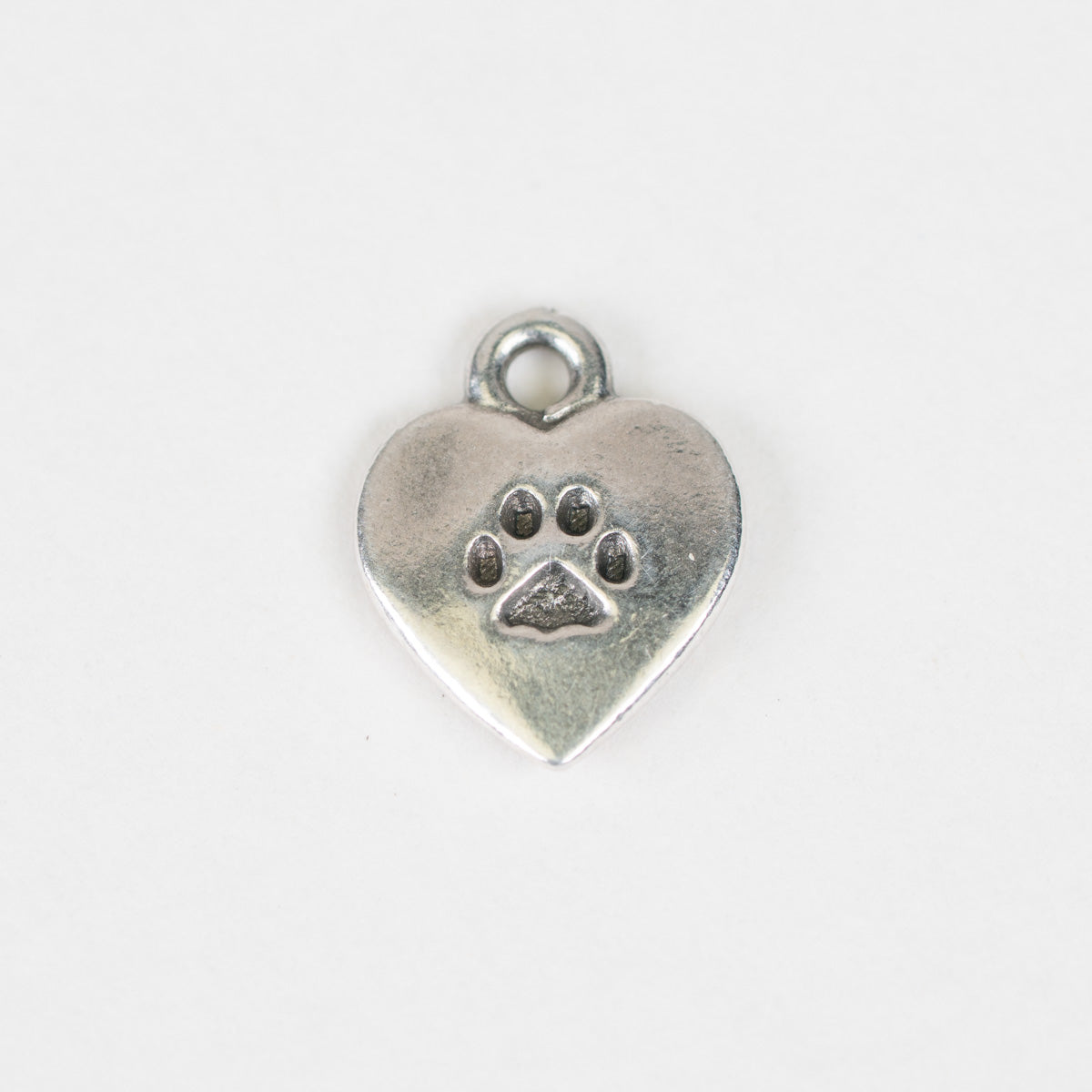 A small silver heart-shaped charm with a paw print design in the center, shown on a plain white background.