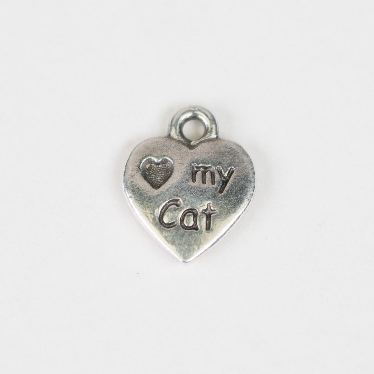 A small silver heart-shaped charm engraved with 'Love my cat' and a heart symbol, shown on a plain white background.