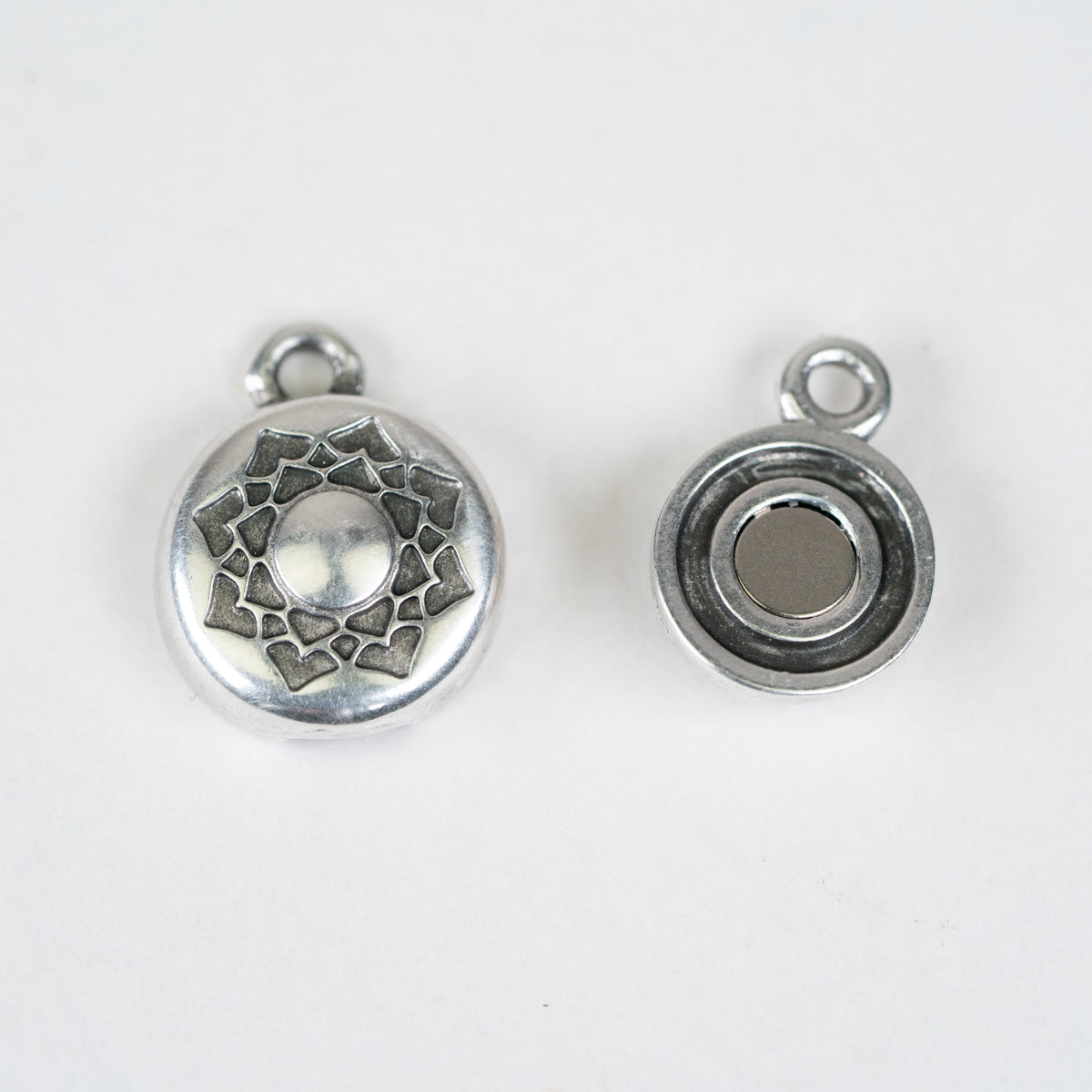 Two silver metal round button charms with loops at the top, shown from front and back on a plain white background.