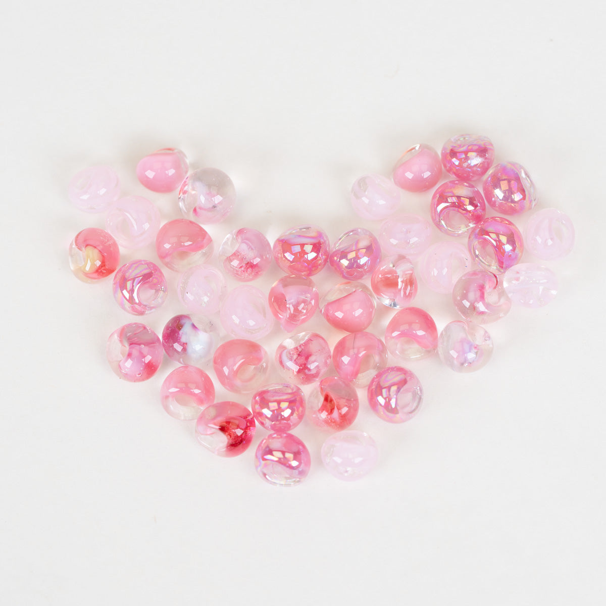 40 pink beads in the form of a heart on a plain white background