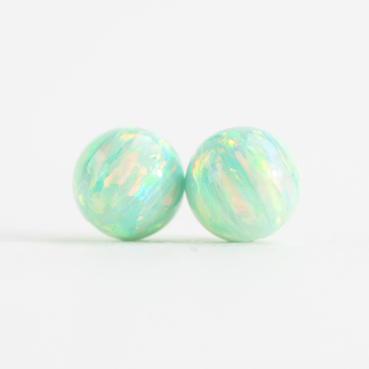 Pair of opal stud beads on a white background