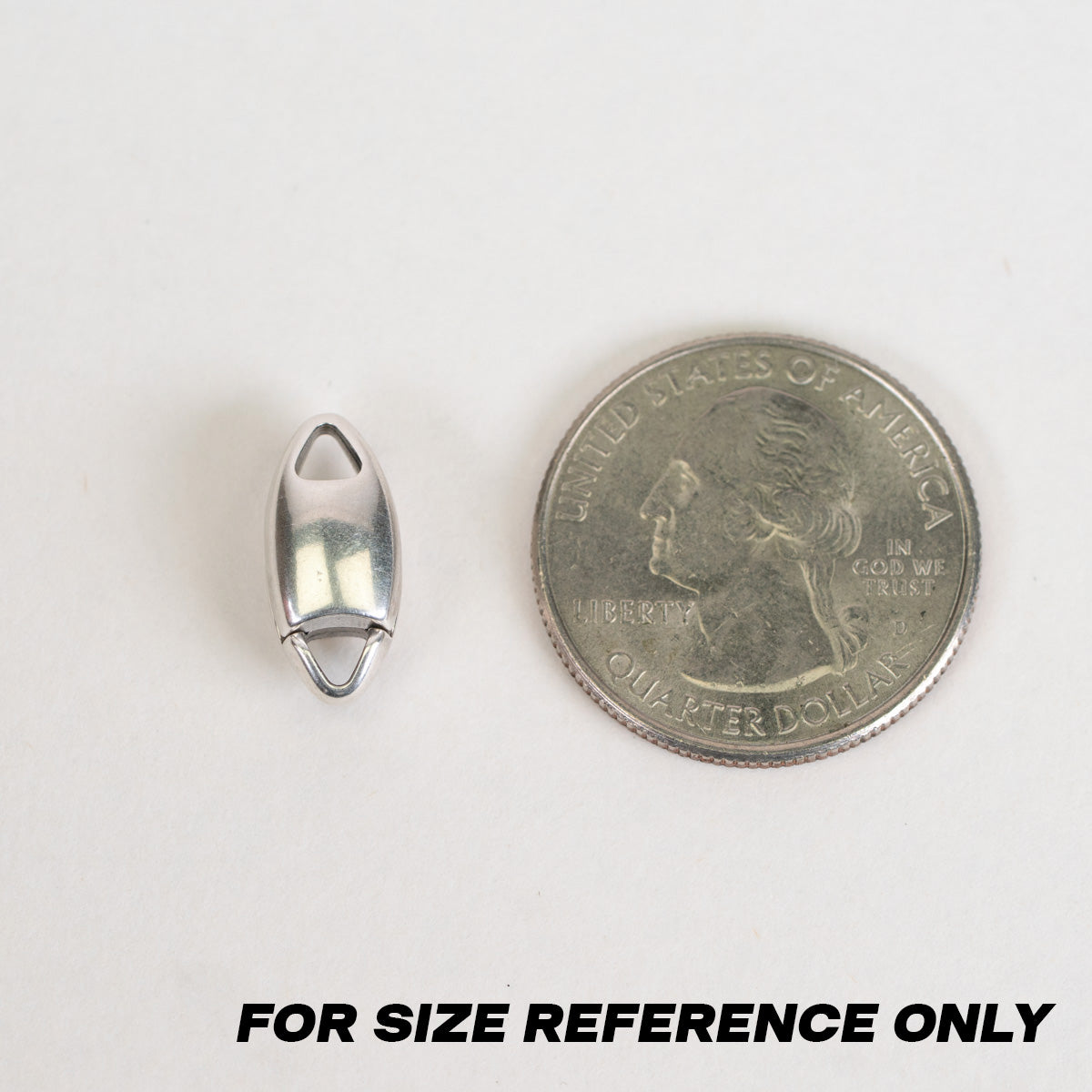 A small silver metal jewelry bead shown next to a U.S. quarter