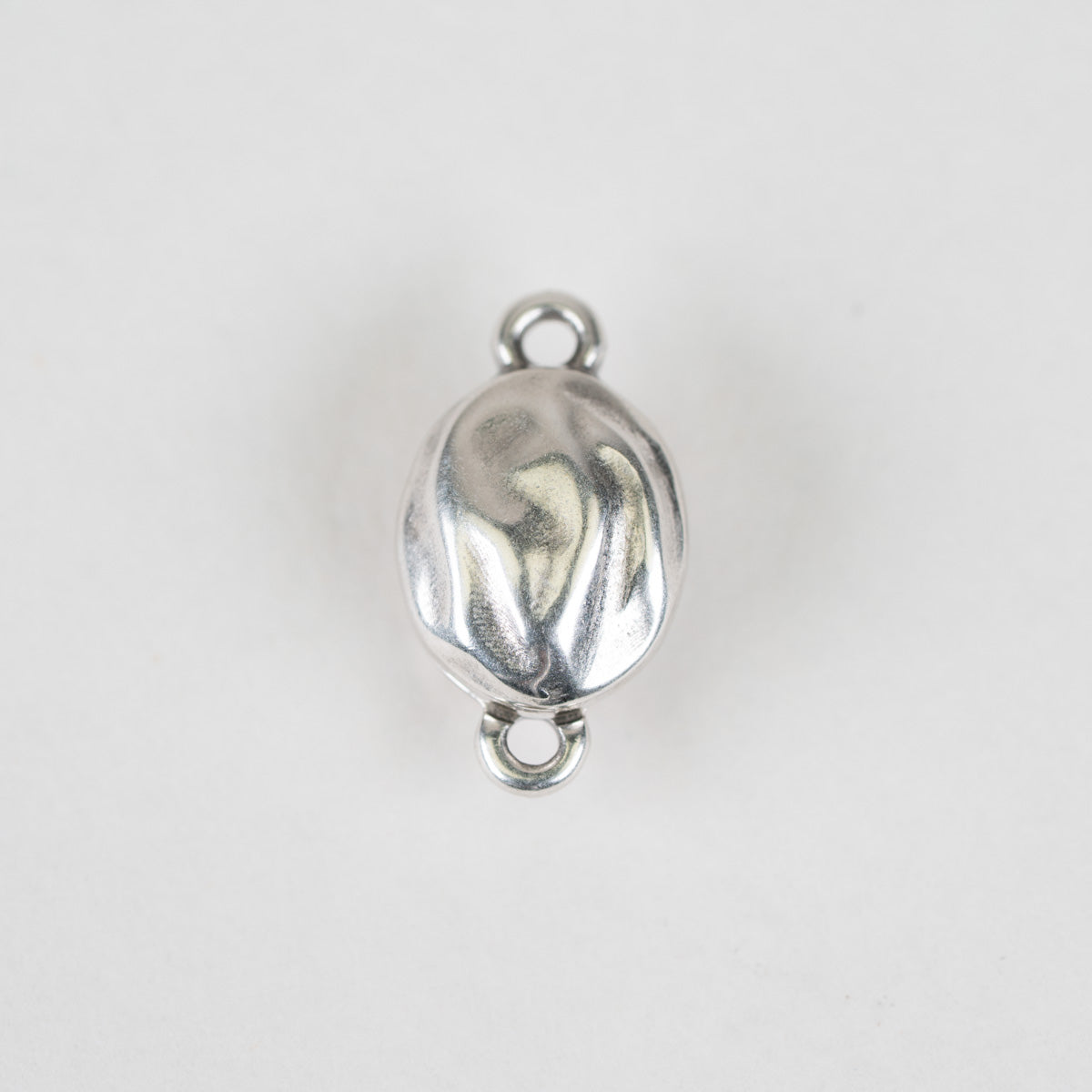 A single polished silver oval charm or bead with a textured, hammered surface and two small loops at the top and bottom, shown on a plain light gray background.