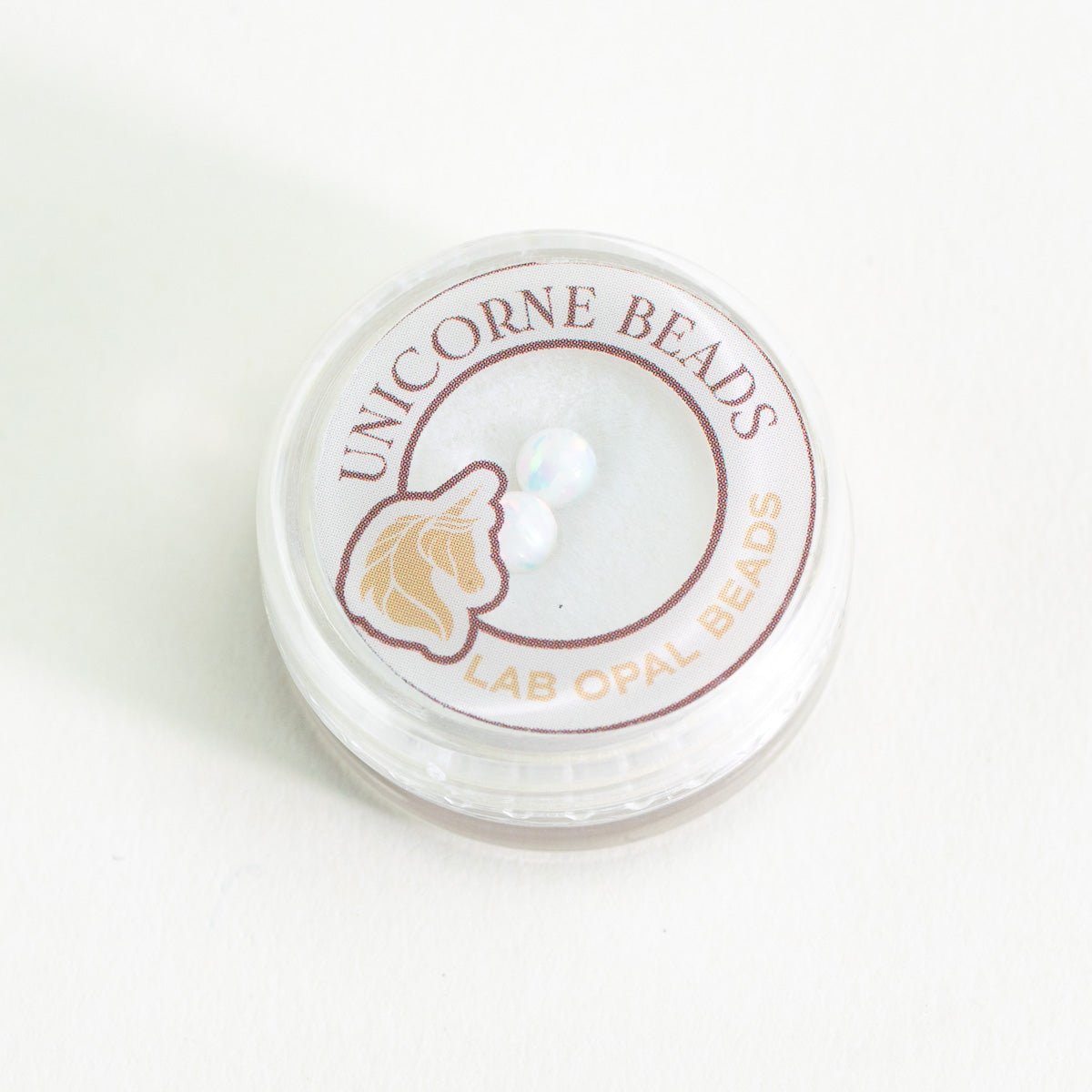 Container of Unicorne Beads Lab Opal Beads on a white background