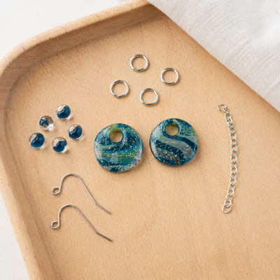The components of a DIY glass bead kit by Unicorne beads showcasing glass beads and jewelry hardware