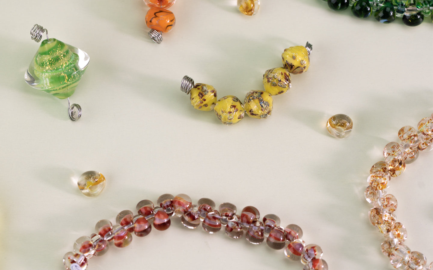 Assortment of multicolored beads on light green background