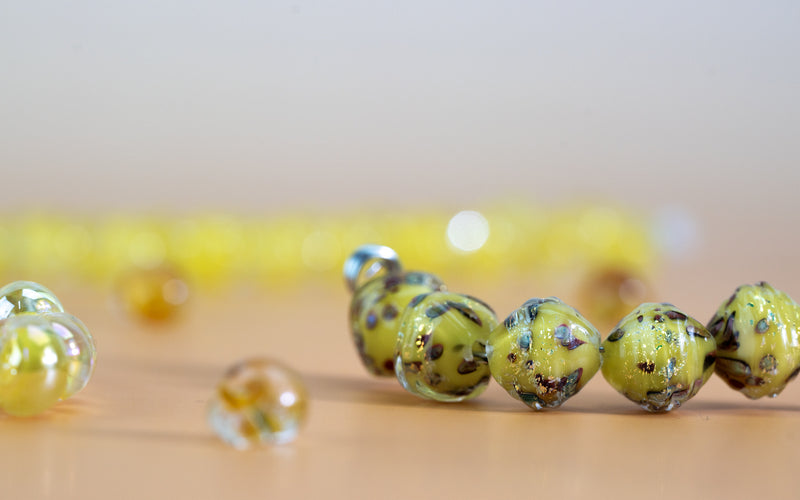 Yellow glass beads on yellow background and surface