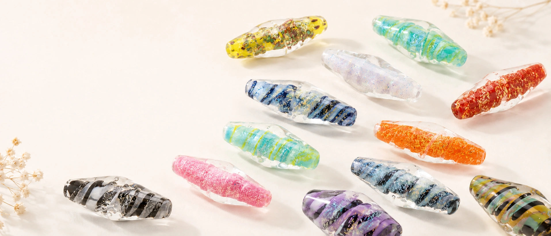 An assortment of glass bicone beads made by Unicorne Beads on a tan background