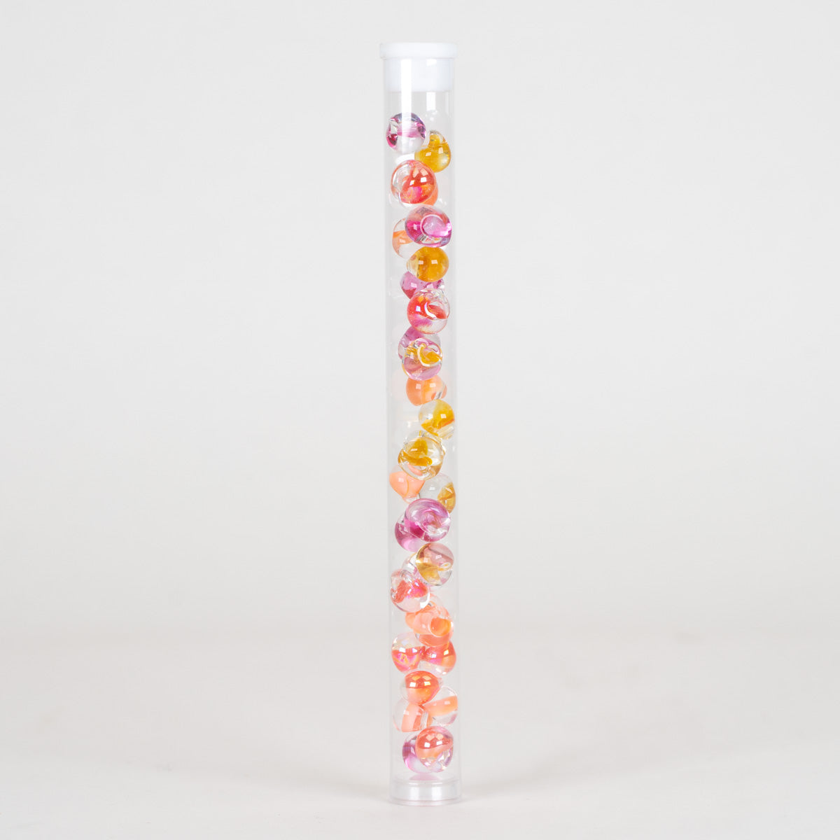 A clear cylindrical plastic tube with a white cap, filled vertically with multiple small round beads in pink, orange, yellow, and purple, photographed on a clean white background.