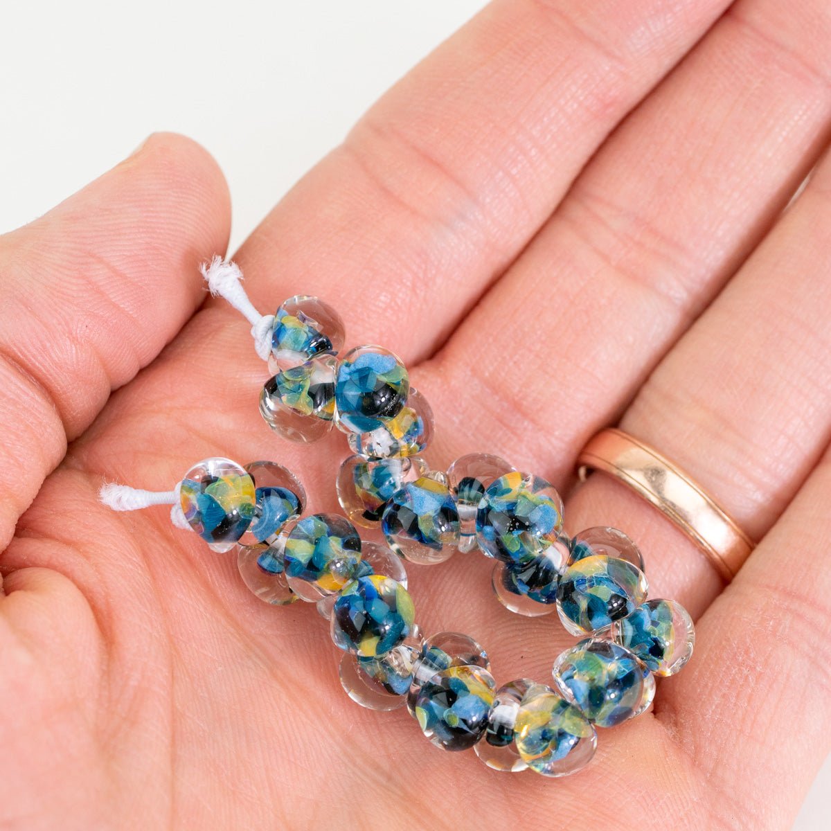 Exotic Series Coral Flourish teardrop glass beads with flowing multicolor pattern in hand