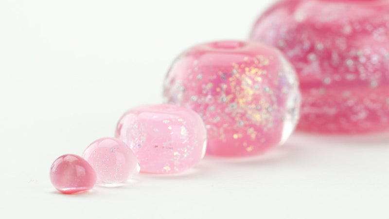 Close up of handcrafted pink glass beads symbolizing support for breast cancer fighters and survivors