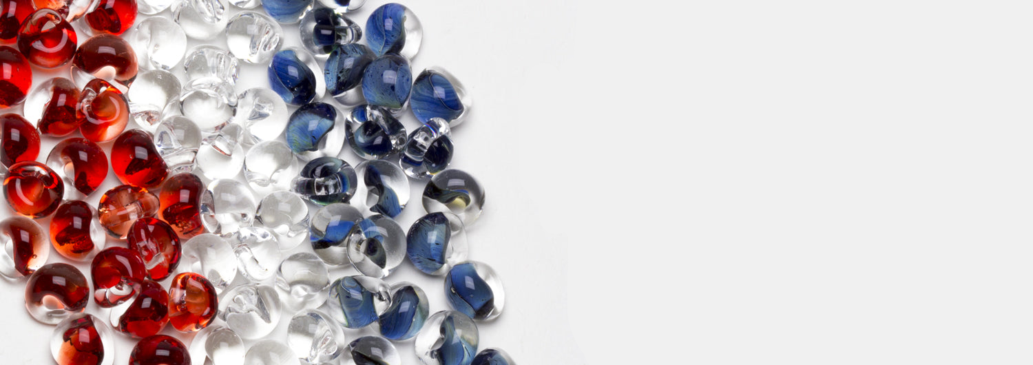 A showcase of red, white, and blue glass beads handblown by Unicorne Beads