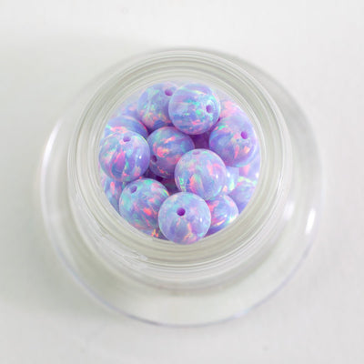 Close up of lavender aurora opal glass beads with soft color variation