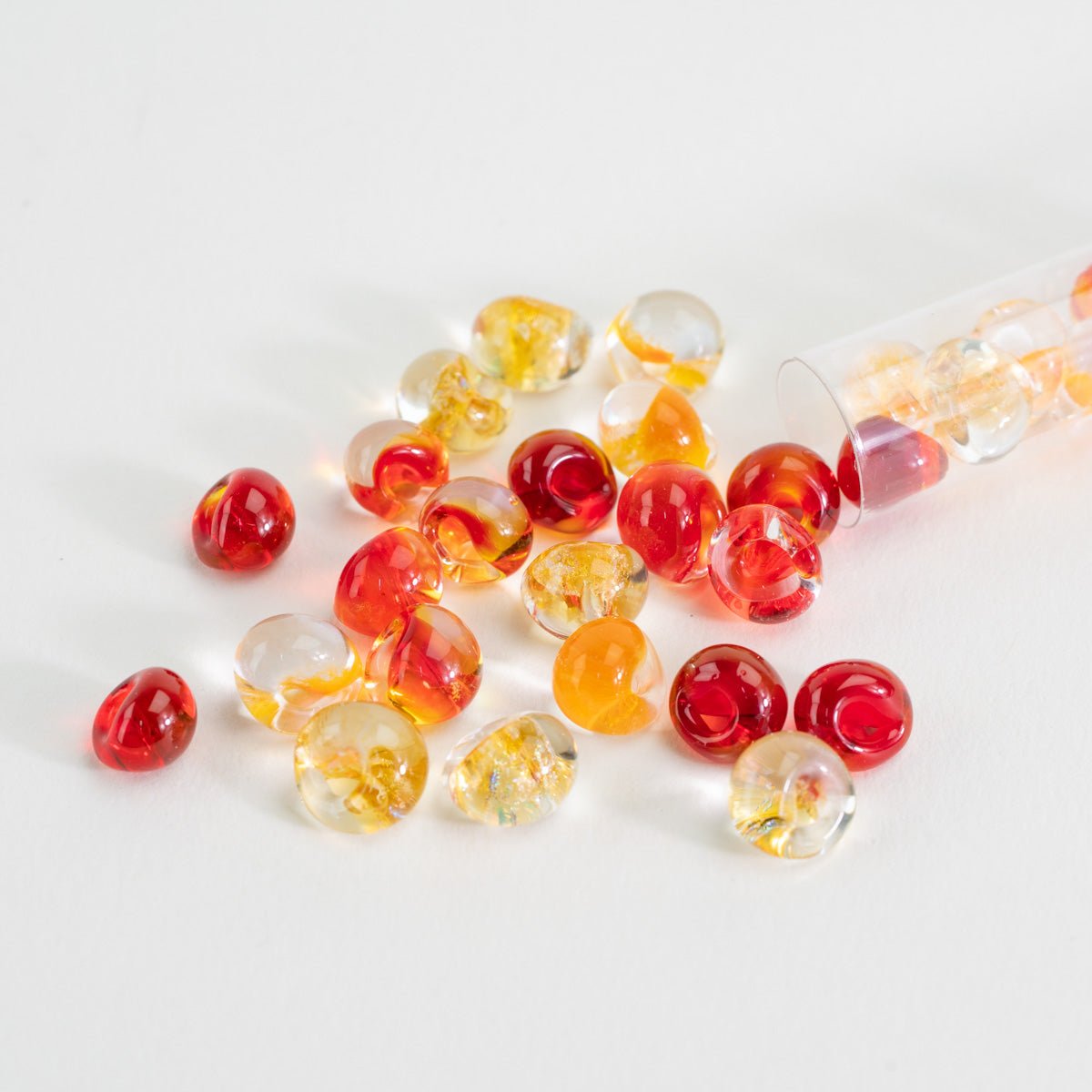 Handcrafted lampwork teardrop beads in red, amber, and golden fire inspired tones