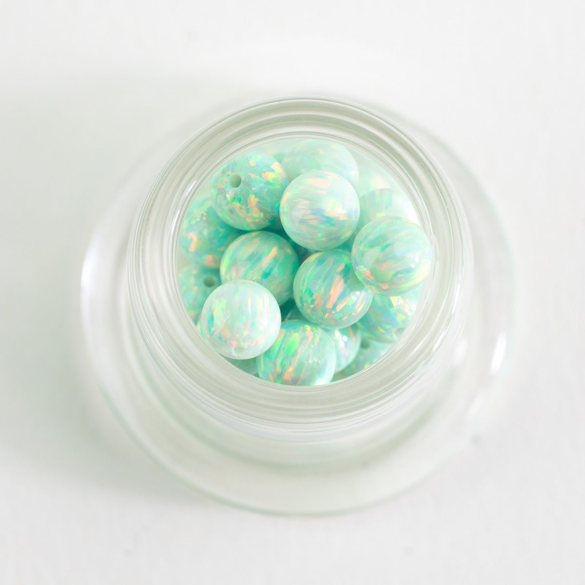 Close up of Seafoam Dream opal glass beads with soft green and iridescent tones