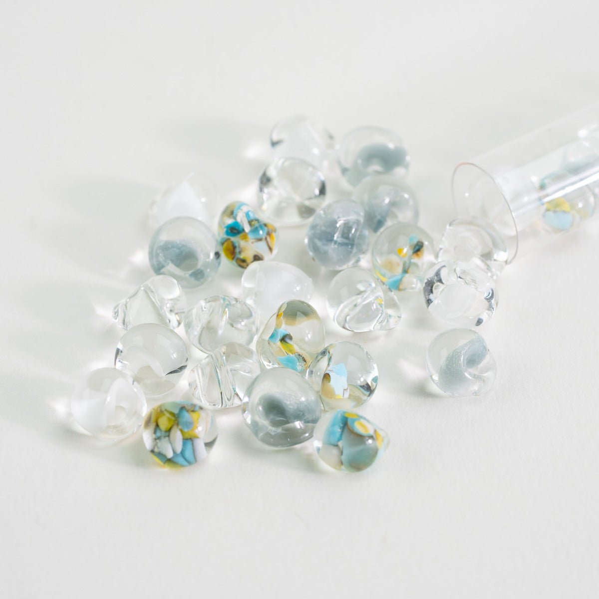 Handcrafted lampwork teardrop beads in soft blue, clear glass, and light airy tones