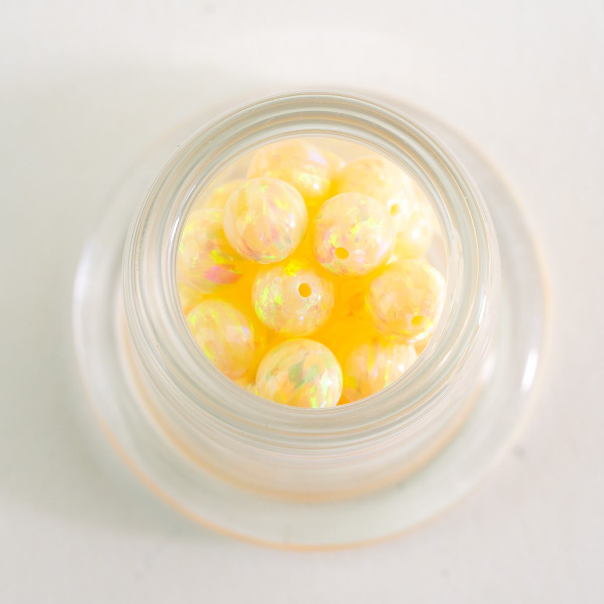 Close up of Solar Bloom opal glass beads with golden and peach color shifts