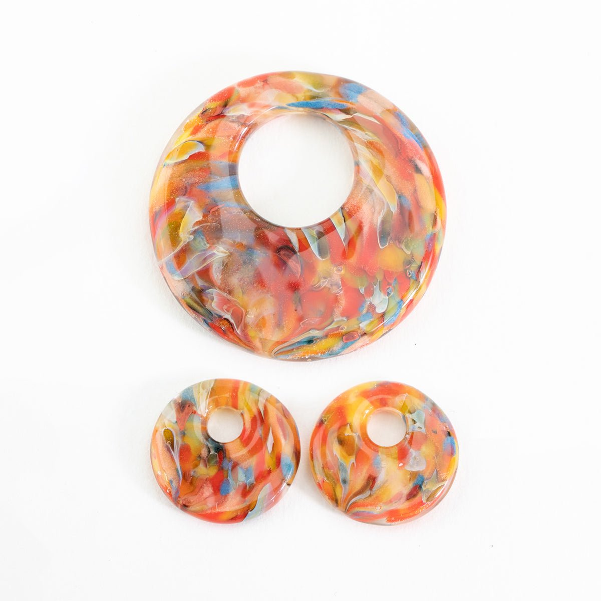 Bird of Paradise halo disk beads showing large and small sizes made from lampwork glass