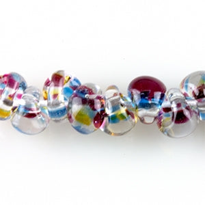  A strand of San Paolo Teardrop glass beads crafted by Unicorne Beads. These glass beads are shaped like teardrops and are multicolored with a clear base. Each glass bead has a hole in the middle to be used for jewelry craft projects.