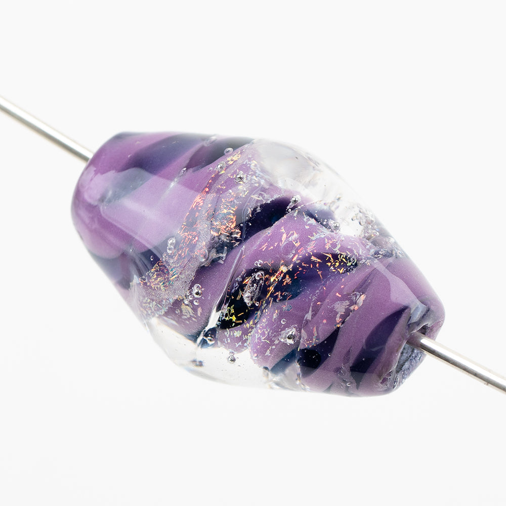 One glass bead on a metal string made up of several shades of purple and a clear external coating. The bead has a hollow center allowing it it be used for jewelry making. 